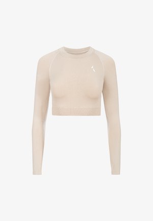 Beige langærmet tætsiddende crop top lavet af et glat, strækbart stof. Har en rund hals og et lille hvidt logo på den øverste venstre side.