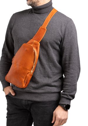 Borsa a tracolla in pelle di un vivace arancione, con una texture liscia, una tasca con zip e una tracolla regolabile. Design casual con bordi arrotondati.