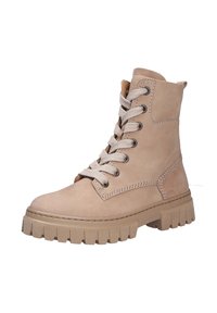 Bottines beiges en daim, avec une tête arrondie, une semelle en caoutchouc épaisse et des lacets beiges avec des œillets en métal et des accents de couture.