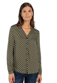 Long-sleeve shirt in dark green with a geometric diamond print in yellow and white. Features a button-down front and collar.