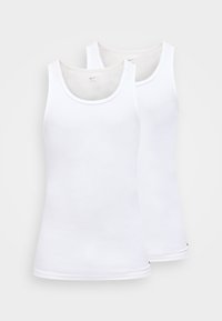 To ensfargede hvite ermeløse Nike-singletter, side om side, på en lys grå bakgrunn.