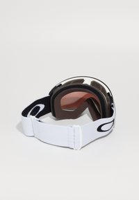 Skibriller med en hvit elastisk stropp, svarte detaljer, brun skumfylling og en tonet linse med metallisk finish.