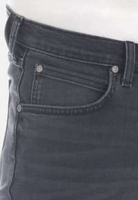 Tmavě šedé džínové kalhoty s pětiprvkovým designem kapes, viditelným prošíváním a kovov�ými ozdobami vpředu i na kapsách. Hladká textura.