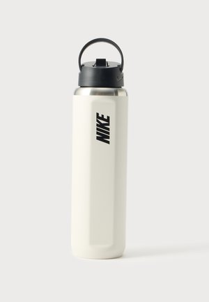 Висока бяла бутилка за вода Nike с черен капак и дръжка за носене на обикновен светъл фон.
