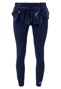 Marina atletiska leggings med en fäst volangöverdrag. Volangen har en glänsande textur, medan leggingsen har en slät yta. Elastisk midja.