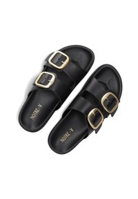 Black slide sandals with two wide straps, gold buckles, and a smooth matte texture. Logo "NOTRE-V" printed on the insole.