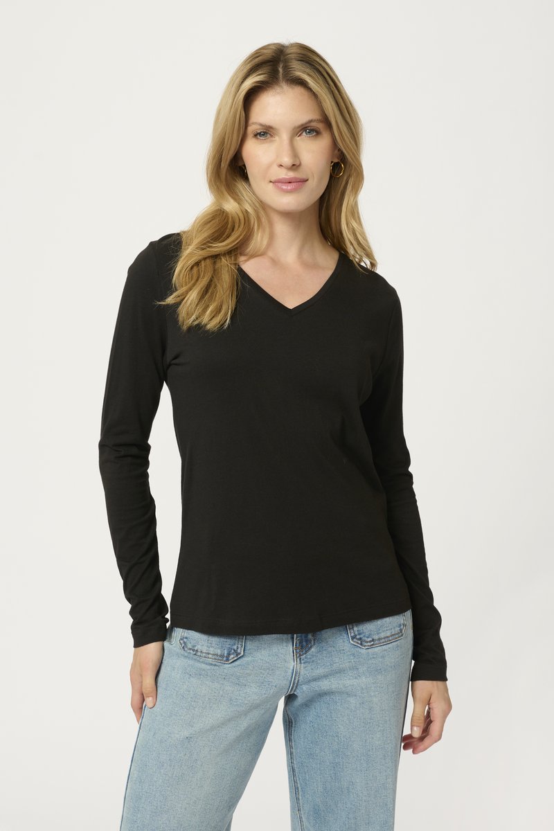 Fekete, hosszú ujjú, V nyakú póló puha anyagból, világoskék, magas derekú farmernadrággal párosítva. Egyszerű dizájn, látható minták nélkül.