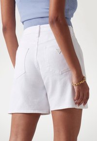 Witte denim shorts met een gladde textuur, voorzien van twee achterzakken en een klein logodetail. De pasvorm is relaxed en heeft een gemiddelde taillehoogte.
