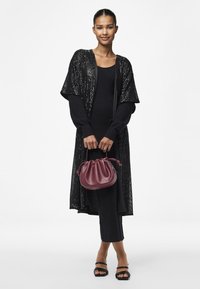 Cardigan lung negru cu paiete, rochie neagră cu textura canelată, geantă de piele bordou cu design strâns, sandale negre cu toc, textură netedă.