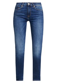 Pantalones vaqueros de mezcla en azul oscuro con un diseño ajustado, que presentan un estilo de cinco bolsillos y un cierre de botón. Ligera decoloración cerca de las rodillas.