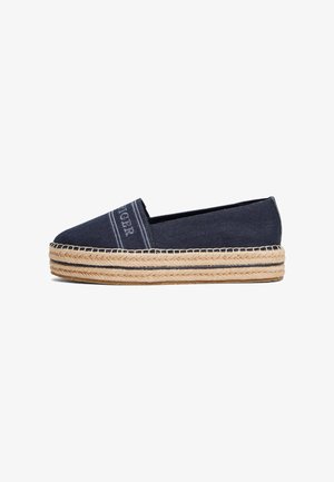 Espadrilha de lona azul-marinho com detalhe de costura e sola em corda de juta. Bico arredondado e design slip-on com salto plano.