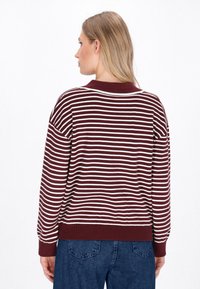 Pullover a righe maroon e bianche con colletto e polsini a coste. Fit morbido, con maniche lunghe e tessuto a maglia testurizzato.