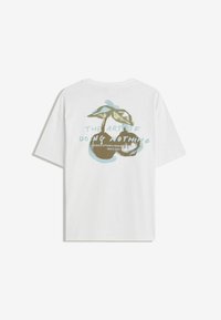 Hvid T-shirt med et grafisk motiv af to kirsebær og blå tekst, der står "Kunsten at lave ingenting" på bagsiden.