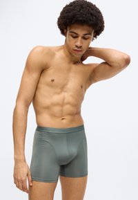Σκούρα πράσινα αντρικά εσώρουχα boxer από λείο, ελαστικό ύφασμα. Διαθέτουν ελαστική μέση με λογότυπο και εφαρμοστή σχεδίαση, προσφέροντας άνεση και στήριξη.