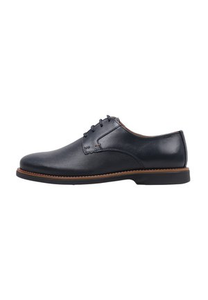 Zapato de vestir para hombre de cuero negro con parte frontal texturizada, cierre de cordones, ribete marrón cosido y suela baja negra.