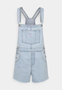 Peto corto de mezclilla azul claro con tirantes ajustables, bolsillo frontal y detalles de botones en los laterales. Textura suave y diseño casual.