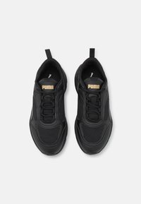Scarpe da ginnastica nere con tomaia in rete e sintetico. Presentano un colletto e una linguetta imbottiti, dettagli testurizzati e il marchio "Puma" in oro.