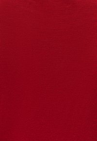 Czerwony prążkowany materiał o gładkiej texture, z pionowymi liniami i jednolitym wyglądem na całej powierzchni.