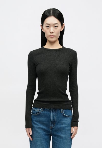 Top de manga comprida escuro com nervuras, decote redondo, silhueta ajustada e textura suave, combinado com jeans de ganga azul claro.