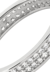 Anneau en argent à finition polie, présentant deux rangées de petites pierres claires et rondes serties en canal. Bords lisses et arrondis.