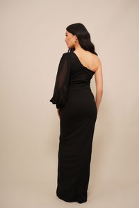 Black one-shoulder dress featuring a fitted silhouette, a sheer puff sleeve, and a zip closure at the back. Smooth texture and elegant shape.