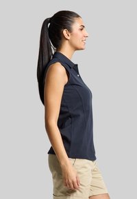 Navyfarbendes ärmelloses Polohemd mit Kragen, ausgestattet mit einem Knopf am Hals und einer taillierten Passform. Kombiniert mit hellbeigen Shorts aus einem glatten Material.