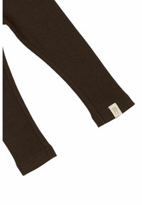 T-shirt à manches longues marron côtelé avec une étiquette à lettres en relief au niveau du poignet. Le tissu semble doux avec une finition texturée.