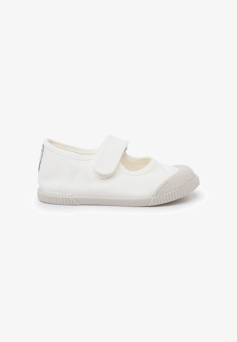Chaussure en toile blanche pour enfants, avec embout et semelle en caoutchouc, dotée d'une seule bride Velcro sur le dessus.