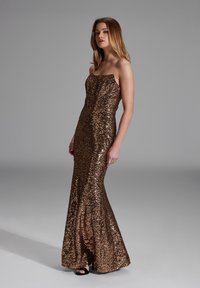 Vestido de lentejuelas bronce con un corsé ajustado, diseño sin tirantes y silueta de sirena, que presenta una textura suave y un brillo sutil.