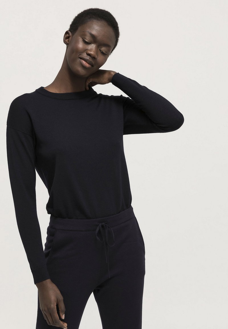 Marineblaues Langarmshirt aus weichem Stoff mit runder Ausschnittsform. Kombiniert mit passenden Jogginghosen mit Kordelzug für einen abgestimmten Look.