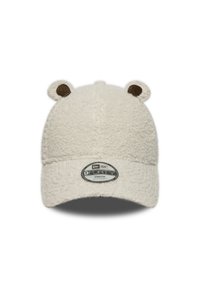 Kremne barve otroška kapa iz mehkega, teksturiranega materiala, okrašena z ušesi medvedka in s poševnim ščitnikom. Ima tudi okroglo nastavljivo označbo spredaj.
