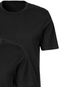 T-shirts en coton noir à col rond, à manches courtes et à texture lisse ; deux t-shirts superposés, sans graphismes ni motifs.