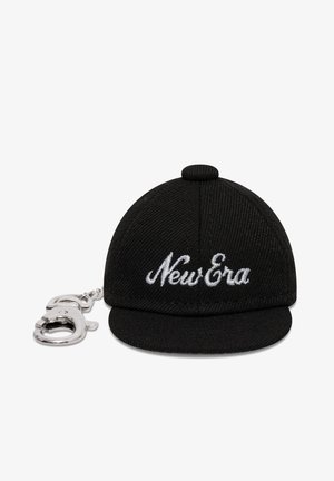 Black miniature baseball cap keychain with white "New Era" embroidery and attached silver metal clip on a white background.