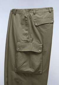 Khaki cargo bukser med tekstureret stof, der har en frontlomme med klap og trykknaplukning, baglomme med lap og bæltestropper.