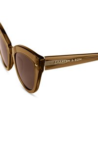 Bruine kunststof zonnebril met donkere lenzen, voorzien van een geometrisch frameontwerp en een metalen accent op de tempel met de merknaam erin gegraveerd.