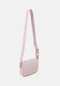 Różowa torebka crossbody z regulowanym paskiem, prostokątnego kształtu, z zamknięciem na zamek błyskawiczny i gładką fakturą; minimalistyczny design bez widocznych wzorów.