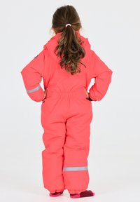 Rosa vadderad snowoverall med huva, elastisk midja och reflexstrimmor på ärmar och ben. Slät textur och lös passform.