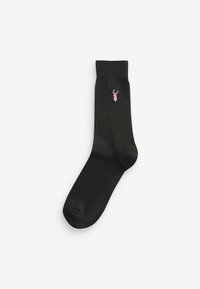 Chaussette noire en coton avec un revers côtelé et un logo de cerf rose brodé sur le côté extérieur. Texture lisse et design classique.