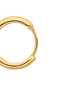 Boucle d'oreille en or avec une forme lisse et arrondie. Présente une légère torsion et une finition polie, améliorant sa qualité réfléchissante.