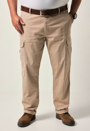 Beige Cargo-Hosen mit mehreren Seitentaschen, hergestellt aus einem strapazierfähigen Stoff. Kombiniert mit braunen Lederschuhen und einem passenden Gürtel.