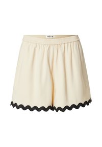 Crème shorts met een elastische tailleband en een zwarte golfrand. Zachte stof met een losse pasvorm en geen extra patronen of hardware.
