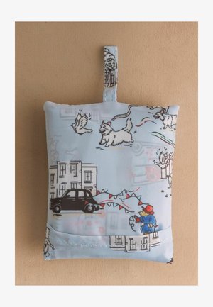 Kis szövetzsák hurokkal, rajzfilm kutyákkal, madarakkal, fekete taxival, épületekkel és egy figurával, aki piros sárkányt reptet, nyomtatva.