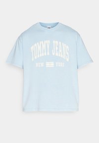 Camiseta de algodón de gran tamaño en azul claro. Presenta un texto blanco en negrita que dice "TOMMY JEANS NEW YORK" en la parte delantera. Mangas cortas.