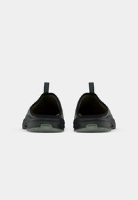 Slip-on sko med en svart og mørkegrønn fargepalett, med en teksturert overflate, buet design og bakre pull-tab for enkel påkledning.