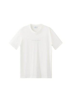 Biała koszulka z krótkim rękawem i okrągłym dekoltem, z małym czarnym napisem "CREATED FOR ADVENTURE" umieszczonym na środku na piersi.