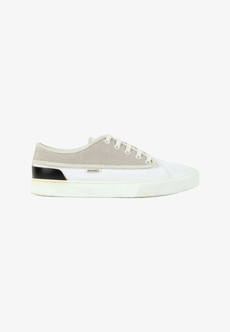 Baskets basses blanches et beige avec lacets, détail talon noir et petite étiquette "Hermès" sur le côté.