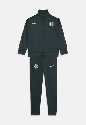Survêtement Nike en vert foncé, comprenant une veste zippée avec un col montant, des poches et un logo, assortie à un pantalon fuselé.