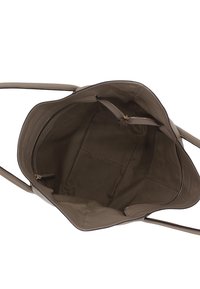 Grande borsa in pelle beige con una texture liscia. L'interno presenta una tasca con zip e due scomparti, evidenziando un design minimalista.