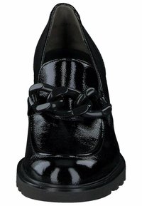 Schwarze Lacklederschuhe mit spitzem Zehenbereich, versehen mit einem klobigen schwarzen Kettendetail über der Vorderseite. Strukturiertes Profil für besseren Halt.