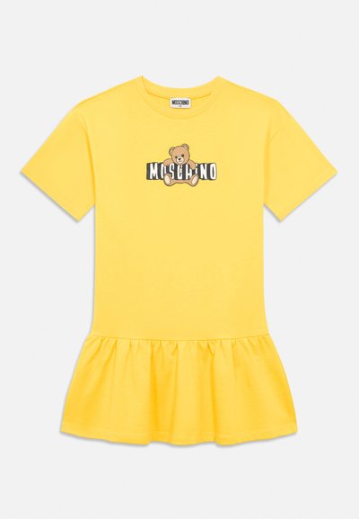 Rumena obleka s kratkimi rokavi in nazobčanim robom, z motivom plišastega medvedka nad napisom "MOSCHINO" na prsih.
